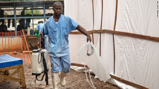 A health worker at the Kenema Government Hospital carries equipment used to decontaminate clothing and equipment on August 9.