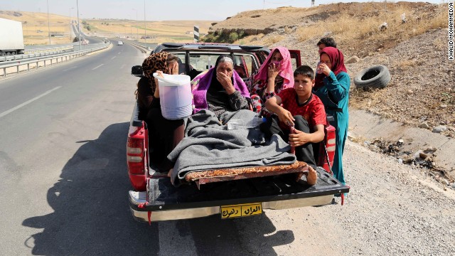 Displaced Iraqis ride on a truck on a mountain road near the Turkish-Iraq border, outside Dahuk, on August 9. 