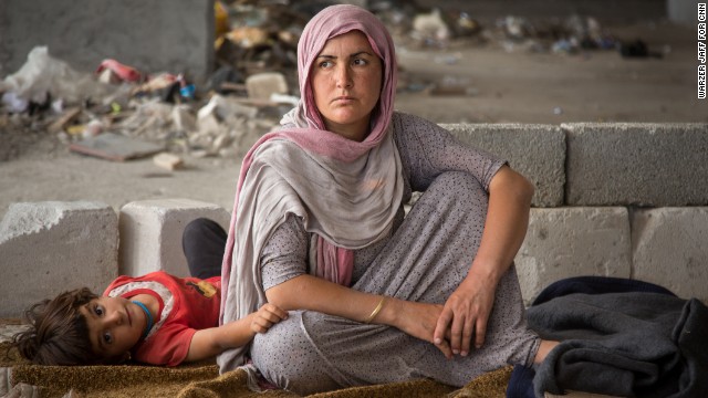 A woman and child sit in the makeshift housing on Thursday.