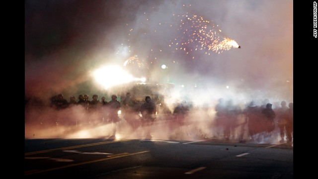 Police stand in clouds of smoke as they clash with protesters on August 13.