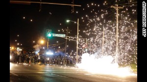 A device deployed by police goes off in the street as police and protesters clash Wednesday.