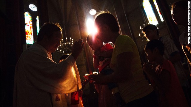 Chinese Catholics takes communion from a priest at a government sanctioned church in Beijing.