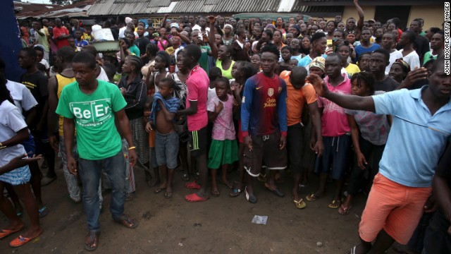 A crowd enters the grounds of an Ebola isolation center in the West Point slum on August 16. The mob was reportedly shouting, "No Ebola in West Point."