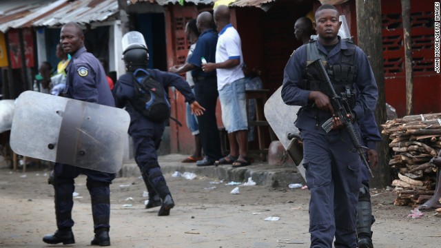 Liberian police depart after firing shots in the air while trying to protect an Ebola burial team in the West Point slum of Monrovia on August 16. A crowd of several hundred local residents reportedly drove away the burial team and their police escort. The mob then forced open an Ebola isolation ward and took patients out, saying the Ebola epidemic is a hoax.