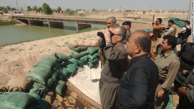 From a position manned by the Kurdish Peshmerga south of Kirkuk, Iraq, Kirkuk Governor Najm al-Din Omar looks through binoculars toward Islamist jihadist positions on August 17.