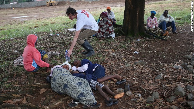 Brett Adamson, a staff member from Doctors Without Borders, hands out water to sick Liberians hoping to enter the new Ebola treatment center on August 17.