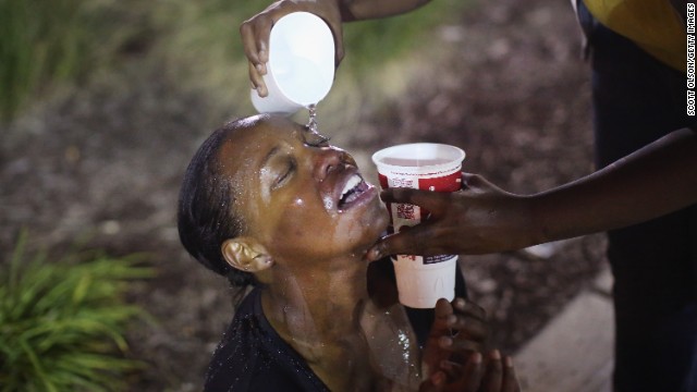 Water gets poured into a woman's eyes after a tear gas attack by police on August 17.