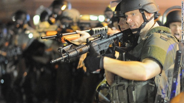 Officers stand with weapons drawn during a protest on West Florissant Avenue on August 18.