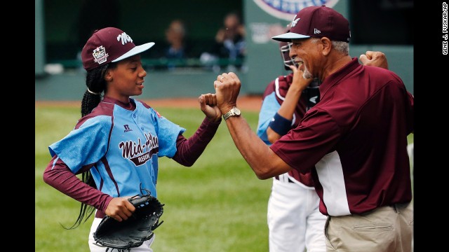 Davis, who pitches for Philadelphia's Taney Dragons, receives congratulations from coach Leland Lott as she returns to the dugout during the shutout game August 15 against South Nashville.