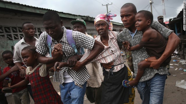 Family members of West Point district commissioner Miata Flowers flee the slum in Monrovia, Liberia, while being escorted by the Ebola Task Force on Wednesday, August 20.