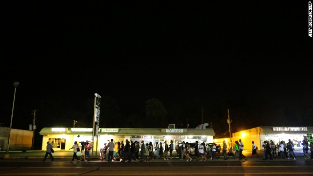 Protesters march in Ferguson, Missouri, on Thursday, August 21. The St. Louis suburb has been in turmoil since a white police officer, Darren Wilson, fatally shot an unarmed black teenager, Michael Brown, on August 9. Some protesters and law enforcement officers have clashed in the streets, leading to injuries and arrests.