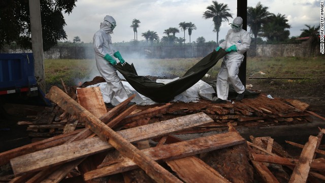 A burial team from the Liberian Ministry of Health unloads bodies of Ebola victims onto a funeral pyre at a crematorium in Marshall, Liberia, on Friday, August 22.