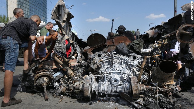 People look at damaged Ukrainian military equipment in Donetsk on August 24. 