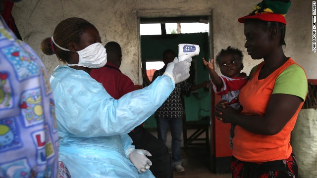 A Liberian Ministry of Health worker checks people for symptoms of Ebola at a checkpoint near the international airport in Dolo Town, Liberia, on August 24.