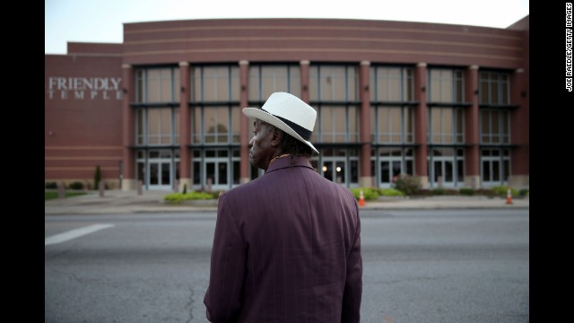 James Wright waits for the Friendly Temple Missionary Baptist Church to open for the funeral service.