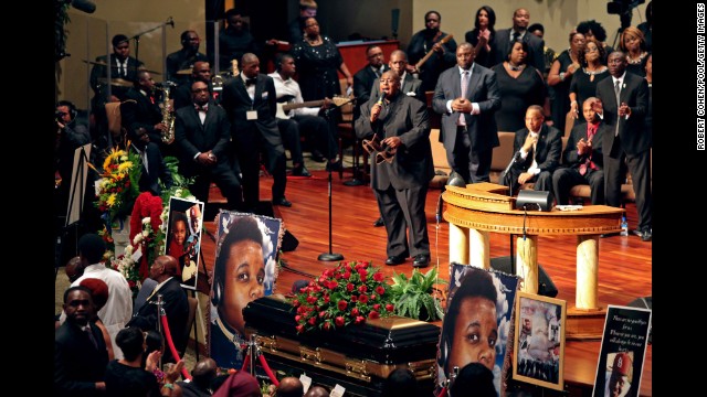 People sing during the funeral for Brown.