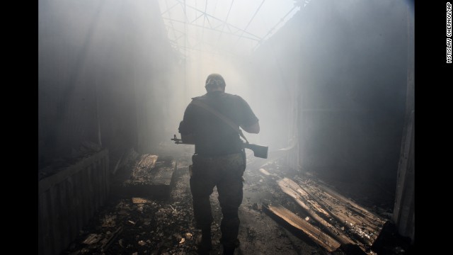 A pro-Russian rebel walks through a local market damaged by shelling in Donetsk, Ukraine, on Tuesday, August 26.