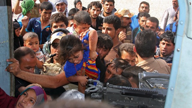 Iraqi Shiite Turkmen, mostly women and children, try to board an Iraqi Army helicopter aid flight bringing supplies to Amerli on Saturday, August 30.