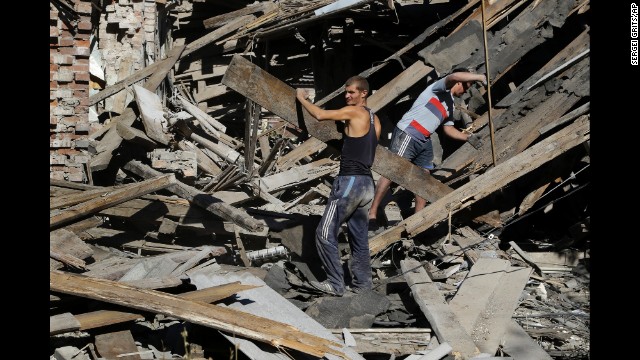Men clear rubble in Ilovaisk on Sunday, August 31.