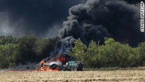 Unmarked military vehicles burn on a country road in Berezove, Ukraine after a clash between Ukrainian troops and pro-Russian separatists.