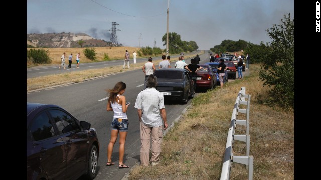 People wait by their cars near Berezove, Ukraine, as rockets hit the road ahead on September 4.