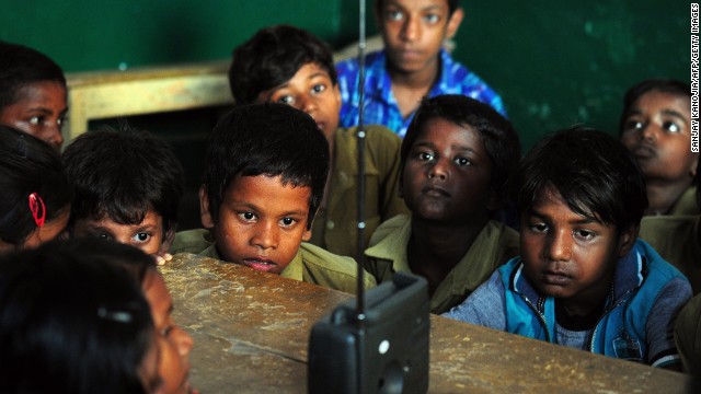 SEPTEMBER 5 - ALLAHABAD, INDIA: Schoolchildren crowd around a radio as they listen to a broadcast by Indian Prime Minister Narendra Modi delivering his Teachers' Day speech at a primary municipal school at Bakshi Kala Daraganj. Modi addressed hundreds of thousands of students during a live telecast to classrooms across India.