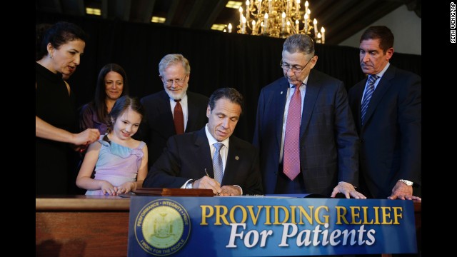 While politicians and supporters look on, New York Governor Andrew Cuomo signs a ceremonial bill to establish a medical marijuana program in New York, on July 7, 2014. New York is the 23rd U.S. state to authorize medical marijuana.
