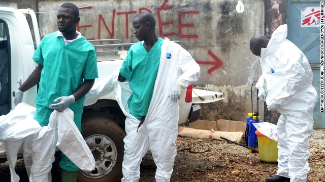 Members of a volunteer medical team wear protective gear before the burying of an Ebola victim Saturday, September 13, in Conakry.