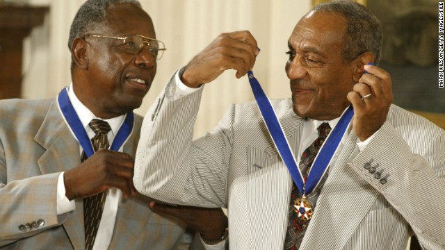 Cosby shares a laugh with baseball great Hank Aaron after they both received the Presidential Medal of Freedom during a 2002 ceremony. The medal is America's highest civilian award.