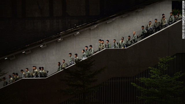 Police walk down a stairwell as demonstrators gather outside government buildings in Hong Kong on September 29.
