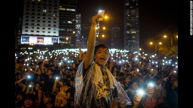Protesters sing songs and wave their cell phones in the air after a massive thunderstorm passed over the Hong Kong Government Complex on September 30.