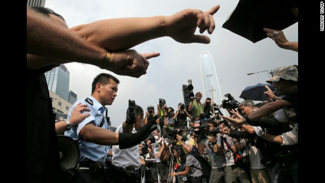 Police raise hands against protesters as an ambulance tries to leave the compound of the chief executive office in Hong Kong on October 3. 