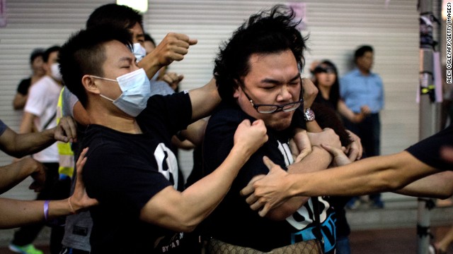 A group of men in masks fight with a man who tried to stop them from removing barricades from a pro-democracy protest area in the Causeway Bay district of Hong Kong on Friday, October 3.