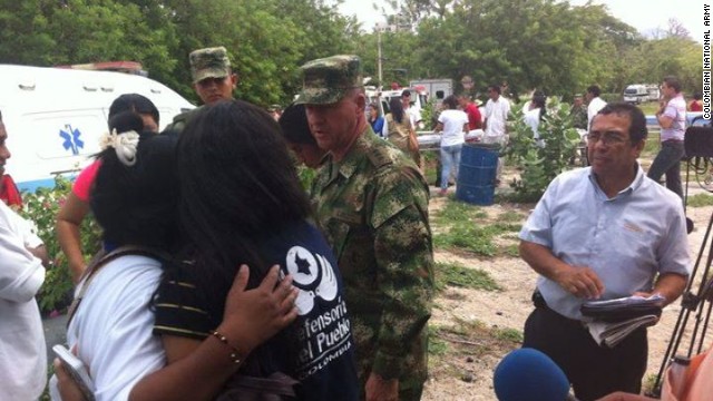 Locals comfort each other after a ceremonial hut caught fire and killed 11 members of an indigenous tribe.