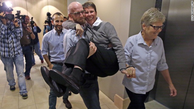 From left, plaintiffs Moudi Sbeity; his partner, Derek Kitchen; Kody Partridge; and Partridge's wife, Laurie Wood, celebrate after a news conference in Salt Lake City on Monday, October 6. The U.S. Supreme Court had just cleared the way for legal same-sex marriages in five more states -- Virginia, Utah, Nevada, Indiana and Wisconsin.