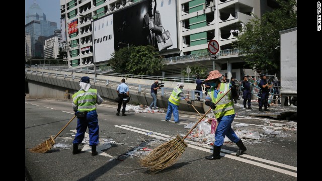 Cleaners sweep the main road after the police's removal of barricades on October 14.