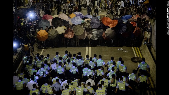 Police move toward pro-democracy protesters during a standoff outside central government offices on October 14.