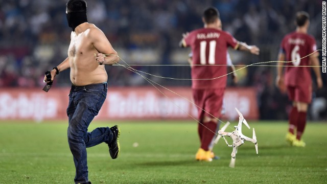 A fan drags the drone behind him after invading the pitch at the Stadion Crvena Zvezda.