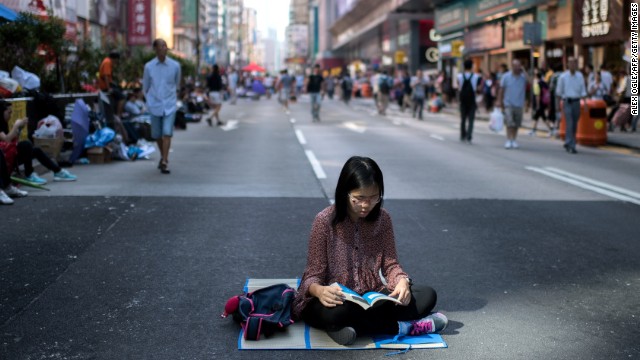 A woman reads on a road barricaded by pro-democracy protesters on October 19.