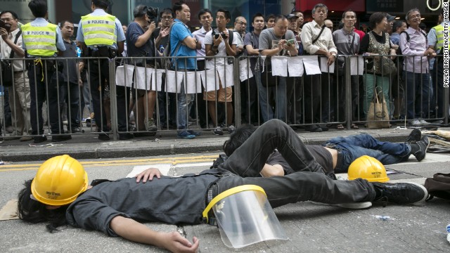 Pro-democracy protesters sleep next to a barricade on October 18 after reclaiming streets in Mong Kok after a night of violent scuffles with police.