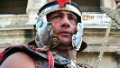 A man as a Roman centurion and who earn his living by posing with tourists gestures in front of the Colosseum during a protest where some of his colleagues climbed on the monument on April 12, 2012 in Rome. The costumed centurions are asking for the right to work there after they were banned following a decision by local authorities. 