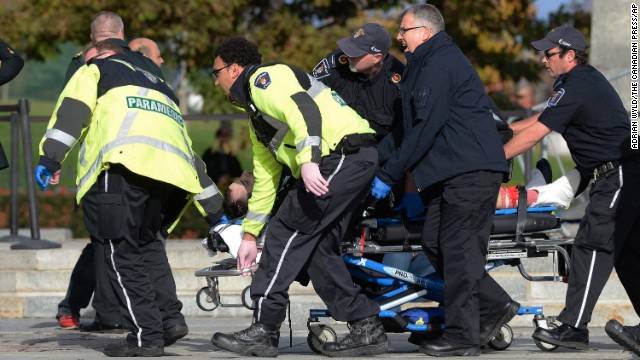 Paramedics and police pull a shooting victim away from the war memorial.