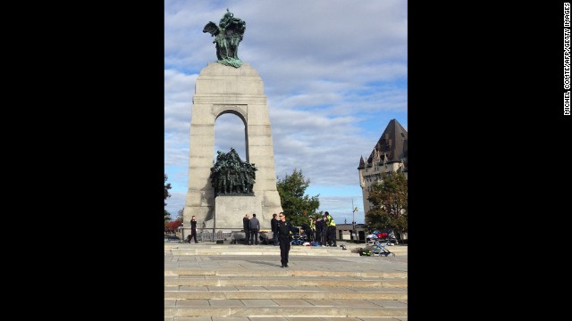 Police and medical personnel work at the scene of the shooting at the war memorial.