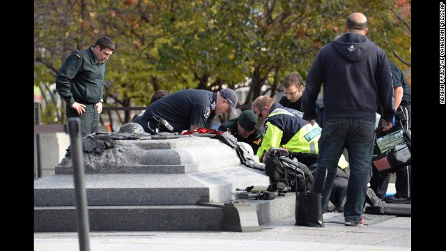 Emergency personnel tend to a person who was shot Wednesday, October 22, at Canada's National War Memorial, which is near the Parliament building in Ottawa. One person was shot at the war memorial, police said, and there were media reports that gunfire was also heard in Parliament.