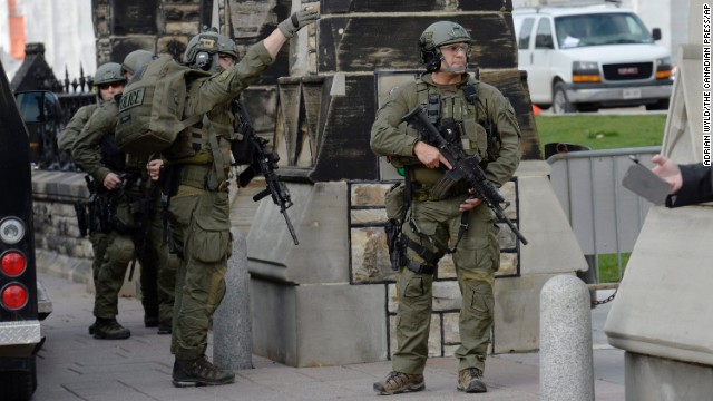 Police walk past a gate on Parliament Hill.