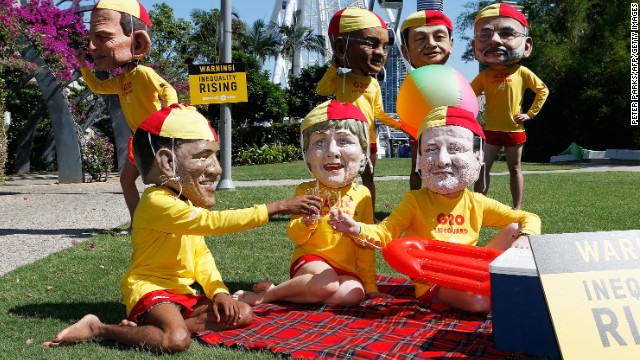 Protesters, wearing fiberglass heads depicting world leaders, pose in the park as they campaign for greater global equality during G20 in Brisbane.