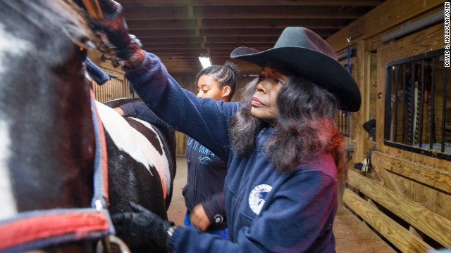 Patricia Kelly grooms a horse on her farm in Hartford, Connecticut. Kelly's nonprofit, Ebony Horsewomen, teaches horseback riding and animal science to at-risk youths, offering them an alternative to the streets.