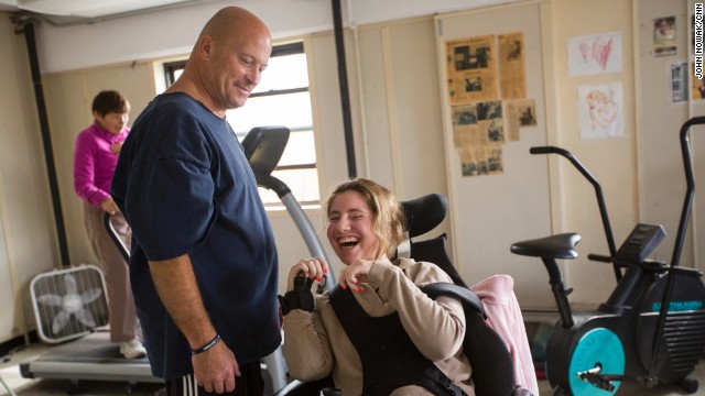 Ned Norton works with a woman at his gym in Albany, New York. For the past 25 years, Norton has provided free and low-cost strength training for people living with disabilities.