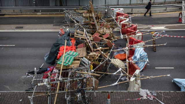 A businessman walks to work past protester-placed barricades that blocked a road at the Admiralty protest site on Thursday, November 13.