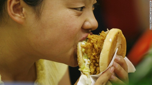  A woman eats a burger at a fast food restaurant in Beijing. China leads the world in diabetes, and is second in TB cases. 